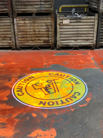 Laserglow's SafetyCast Projected Signage is visible in rough industrial settings